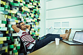 Man relaxing at desk in office