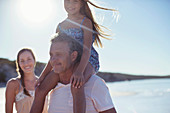 Father holding daughter on shoulders