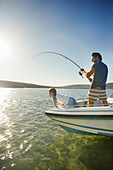 Father and son fishing on boat