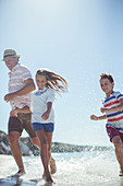 Family running in water on beach