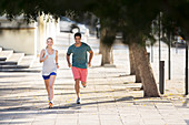 Couple running through city streets