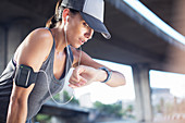 Woman looking at watch after exercising