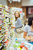 Smiling woman shopping in grocery store