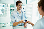 Man paying with credit card in drugstore