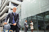 Businessman walking bicycle