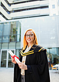 Student in cap and gown holding scroll