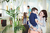 Mother carrying son in hotel lobby