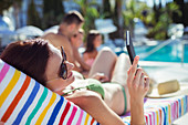 Woman sunbathing and texting