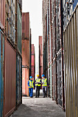 Workers talking between cargo containers
