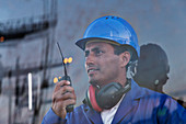 Worker holding walkie-talkie near window