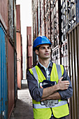 Worker standing between cargo containers