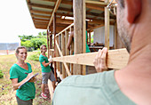 People building wooden house frame
