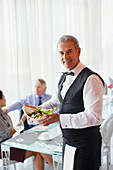 Portrait of waiter holding salad bowl