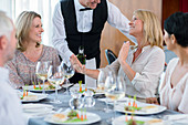 Waiter offering wine to female client