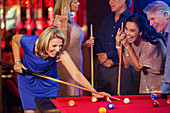 Friends playing pool in nightclub