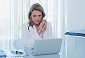 Female doctor sitting at desk with laptop
