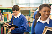 Students holding books in school library