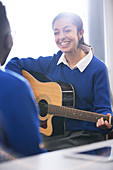 Student playing acoustic guitar