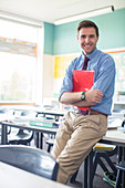 Smiling teacher leaning in classroom