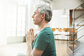 Older man meditating indoors