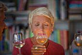 Older woman smelling white wine