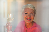 Older woman drinking glass of white wine