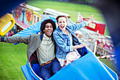 Cheerful couple having fun on carousel