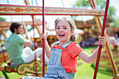Cheerful girl laughing on carousel