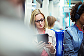Businesswoman using tablet on train