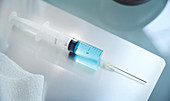 Syringe with blue fluid on table
