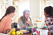 Girls talking at table in dining room