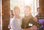 Smiling men hugging at seminar