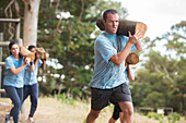 Determined man running with log