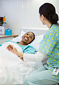 Nurse holding smiling patient's hand