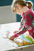 Girl assembling jigsaw puzzle