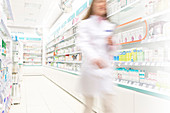 Pharmacist walking in aisle of pharmacy