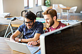 Businessmen working at laptop in office