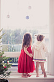 Girls below Christmas ornaments