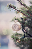 Silver ornament hanging on Christmas tree