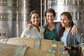 Portrait smiling women in winery cellar