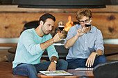 Men wine tasting red wine in winery tasting room