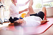Physical therapist stretching man's leg