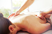 Masseuse massaging woman's back