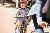 Boy riding bicycle on sunny road