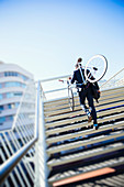 Businessman carrying bicycle