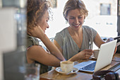 Businesswomen with coffee working in cafe