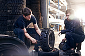Mechanics fixing tire in auto repair shop