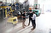 Mechanics talking near forklifts