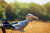 Carefree senior woman relaxing with book