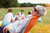 Senior woman relaxing in chair in field